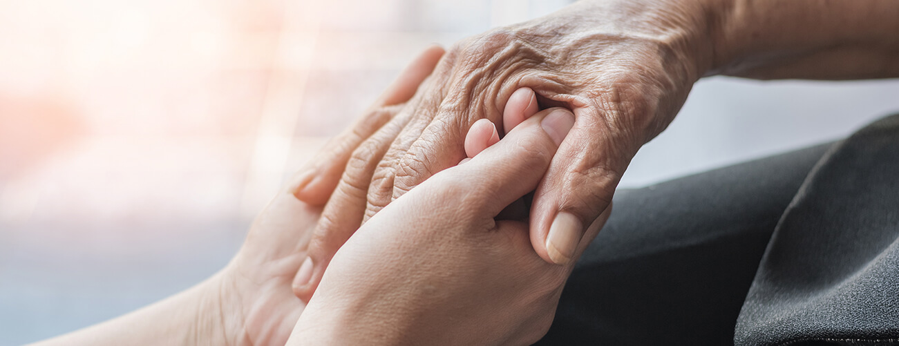 young person holding old persons hands